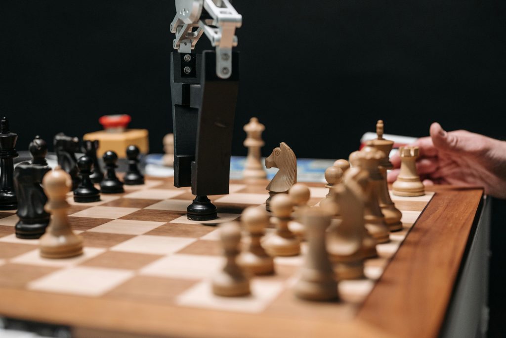 Close-up of a robotic arm playing chess against a human, showcasing AI technology in a classic board game setting.